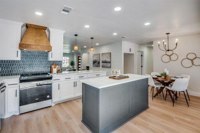 kitchen featuring pendant lighting, white cabinetry, sink, and custom exhaust hood