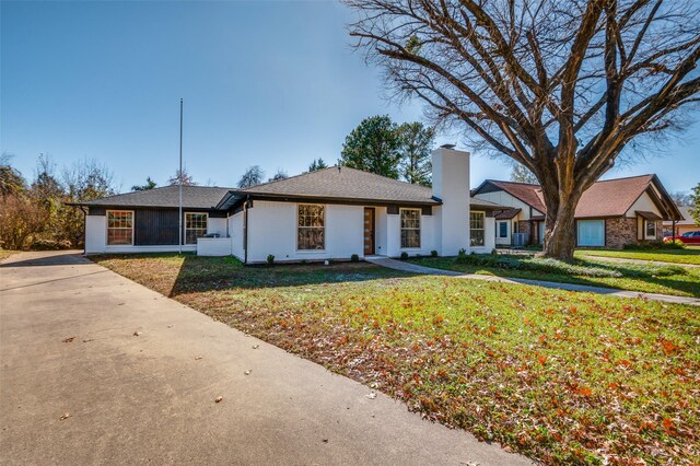 ranch-style home with a front yard and central AC