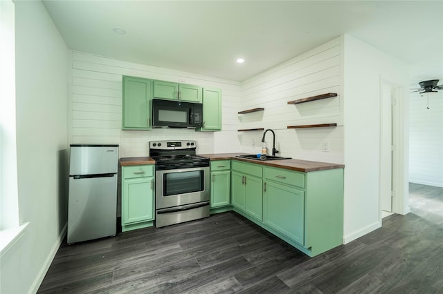 kitchen with dark wood-type flooring, sink, appliances with stainless steel finishes, and wooden counters