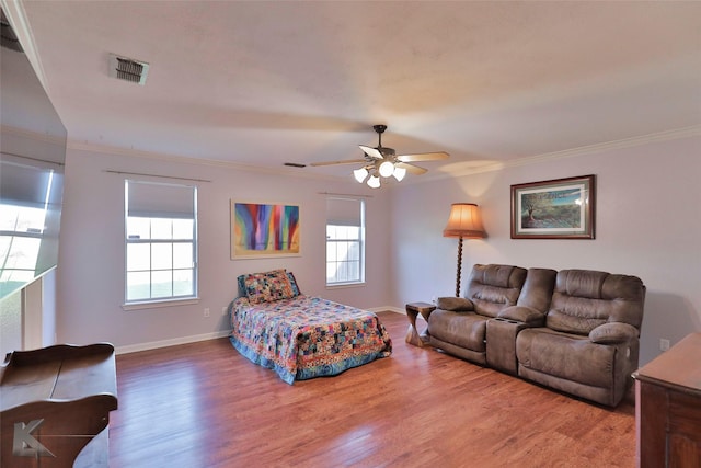 bedroom with wood-type flooring, multiple windows, crown molding, and ceiling fan