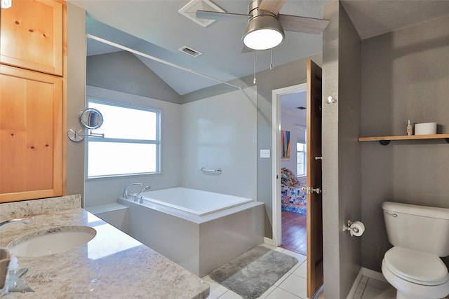 bathroom featuring vanity, lofted ceiling, tile patterned floors, a washtub, and toilet