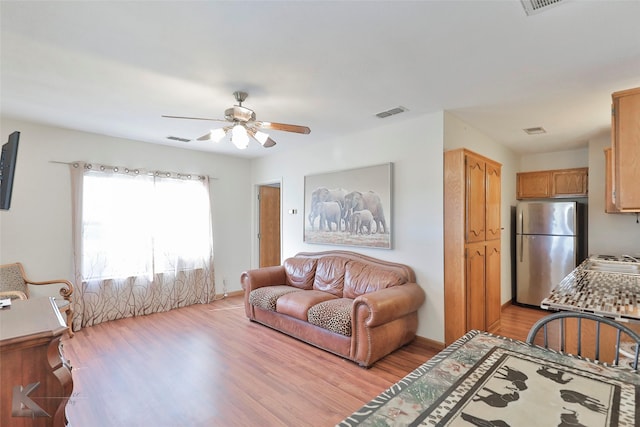 living room featuring ceiling fan and light hardwood / wood-style flooring