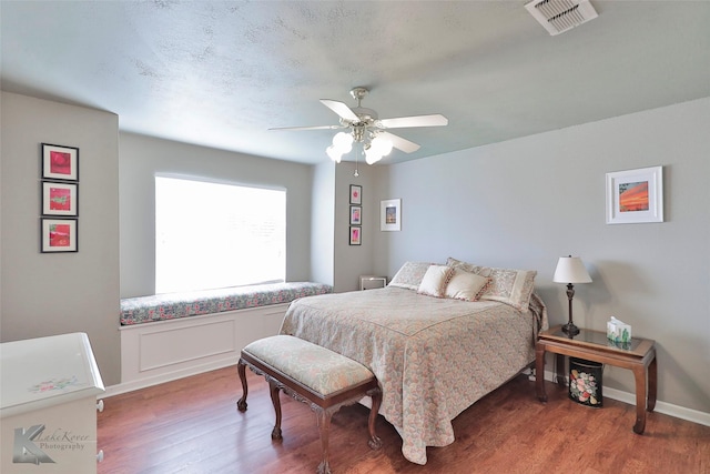 bedroom with ceiling fan and dark hardwood / wood-style floors