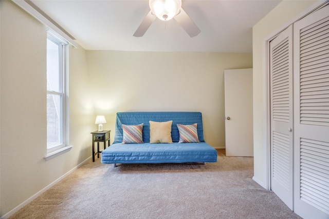 living area featuring light colored carpet and ceiling fan