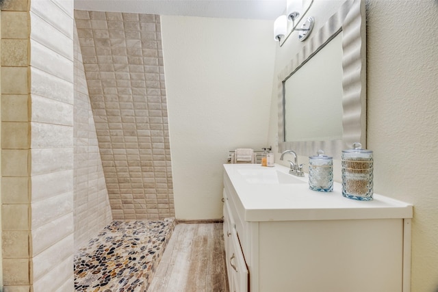 bathroom with vanity, hardwood / wood-style floors, and a tile shower