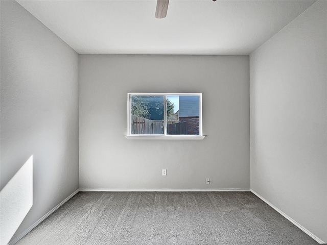 carpeted spare room with ceiling fan