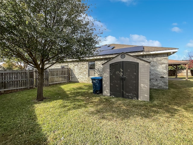 view of outbuilding featuring a yard and solar panels