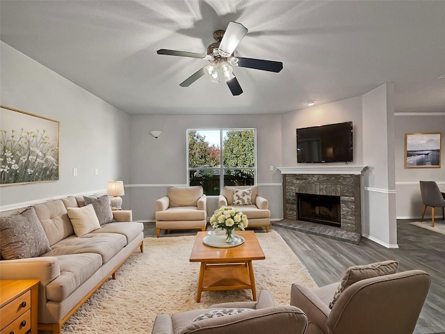 living room featuring a fireplace, hardwood / wood-style floors, and ceiling fan