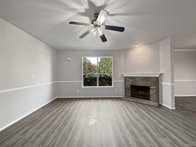 unfurnished living room with hardwood / wood-style flooring, ceiling fan, and a stone fireplace