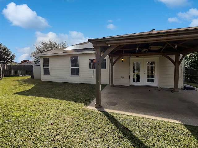 back of property featuring a lawn and french doors