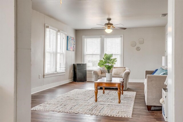 living room with ceiling fan and dark hardwood / wood-style floors