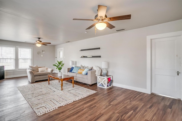 living room featuring ceiling fan and dark wood-type flooring