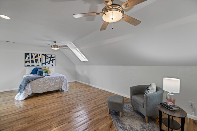 bedroom featuring hardwood / wood-style floors, ceiling fan, and vaulted ceiling with skylight