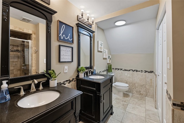 bathroom with walk in shower, vanity, vaulted ceiling, tile walls, and tile patterned flooring