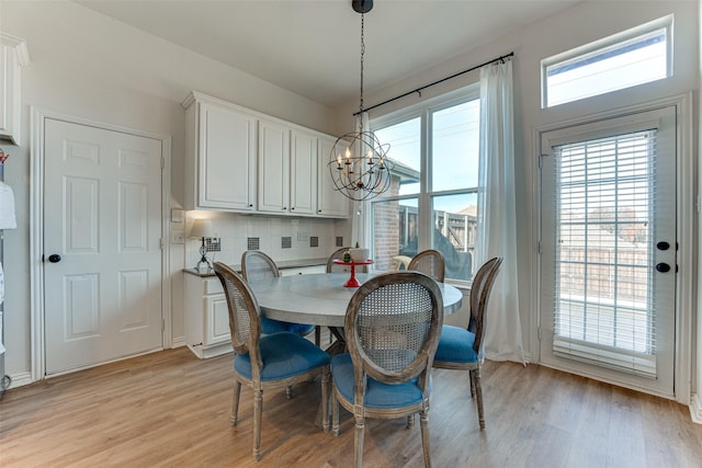 dining room featuring light wood-type flooring and a chandelier