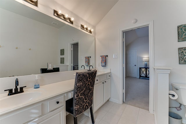 bathroom featuring tile patterned floors, vanity, vaulted ceiling, and toilet