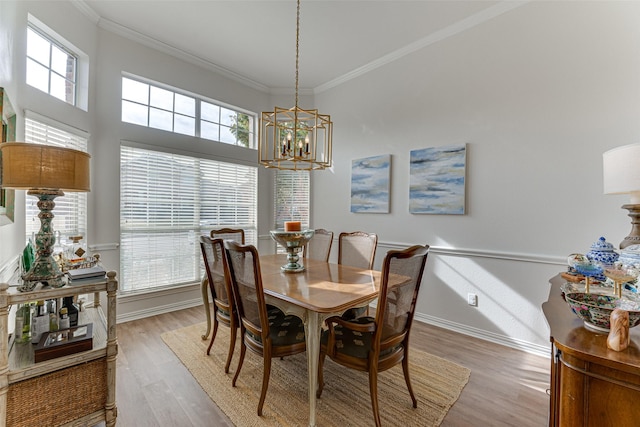 dining room featuring a chandelier, light hardwood / wood-style flooring, a wealth of natural light, and crown molding