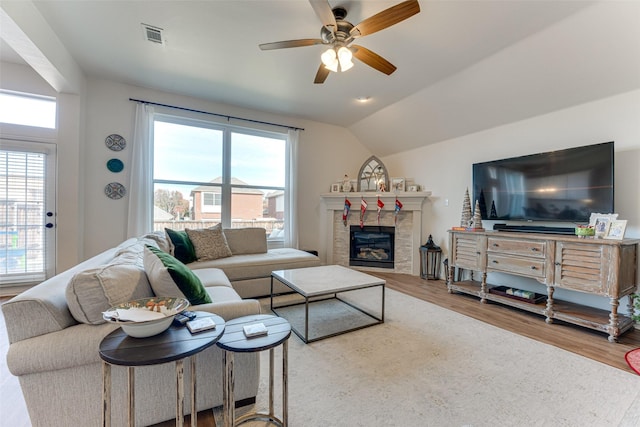 living room with hardwood / wood-style flooring, a wealth of natural light, lofted ceiling, and ceiling fan