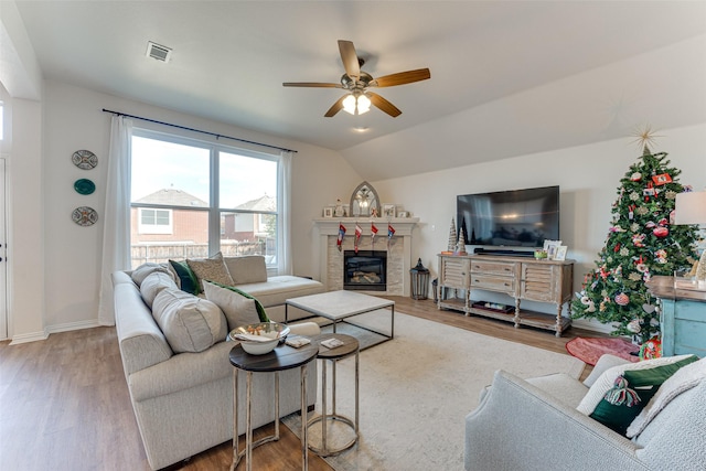 living room with hardwood / wood-style floors, vaulted ceiling, and ceiling fan