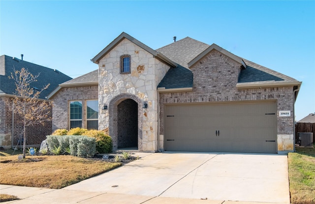 french country home with central AC and a garage