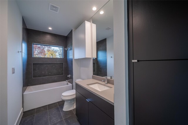 full bathroom with vanity, tiled shower / bath combo, and toilet