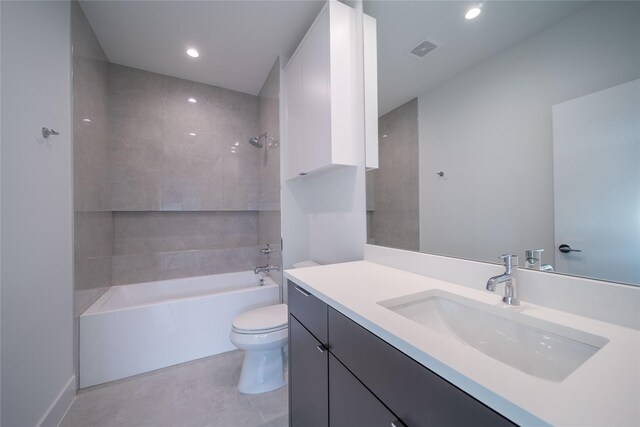 full bathroom featuring tile patterned floors, vanity, tiled shower / bath combo, and toilet