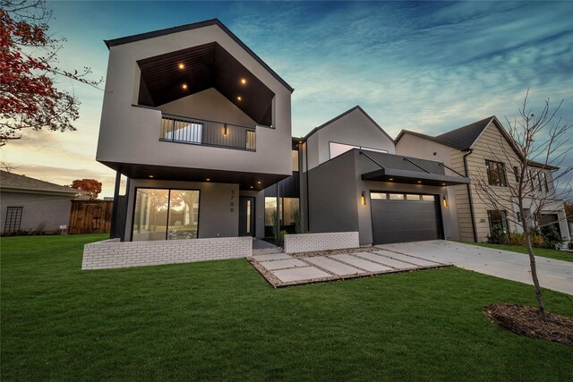 view of front of house with a lawn, a garage, and a balcony