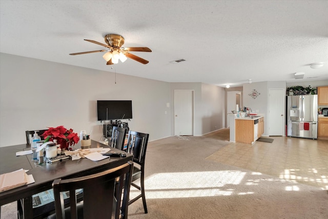 dining room featuring light carpet, a textured ceiling, ceiling fan, and sink