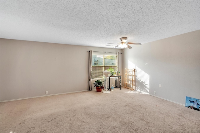 carpeted spare room featuring ceiling fan and a textured ceiling