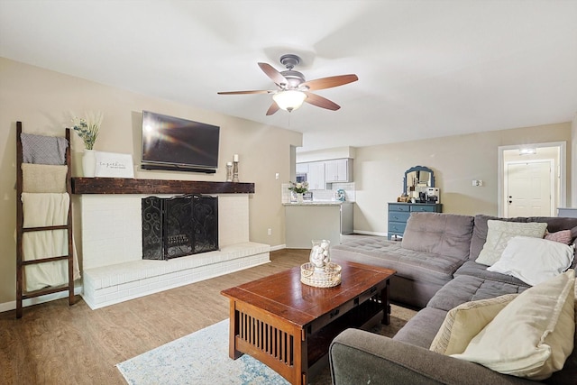 living room featuring hardwood / wood-style floors, ceiling fan, and a fireplace