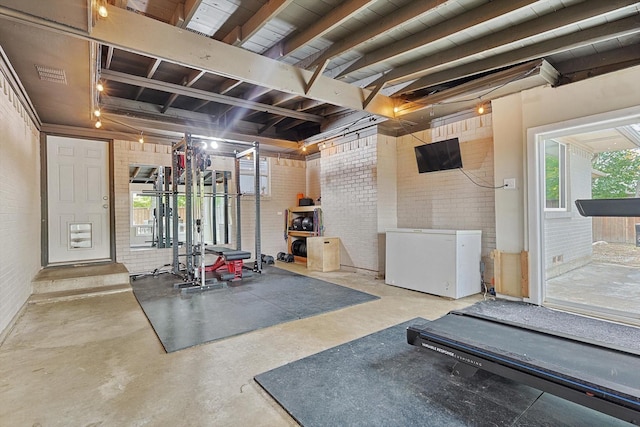 exercise room featuring brick wall