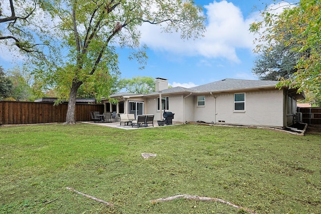 rear view of property featuring a yard and a patio area