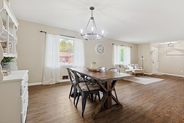 dining area featuring a chandelier, a healthy amount of sunlight, and dark hardwood / wood-style floors