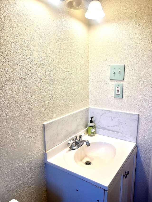 bathroom featuring vanity and a textured wall