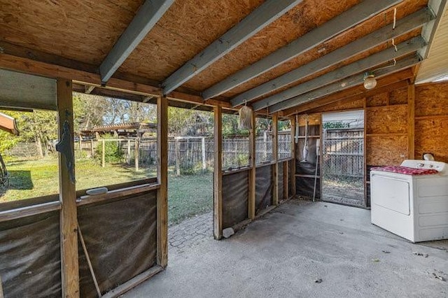 unfurnished sunroom featuring washer / clothes dryer and vaulted ceiling