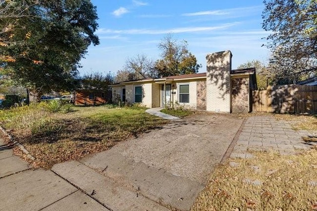 view of front of property with fence, driveway, and a chimney