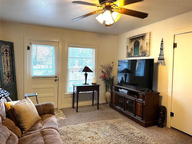 living room featuring a textured ceiling, ceiling fan, crown molding, and light carpet