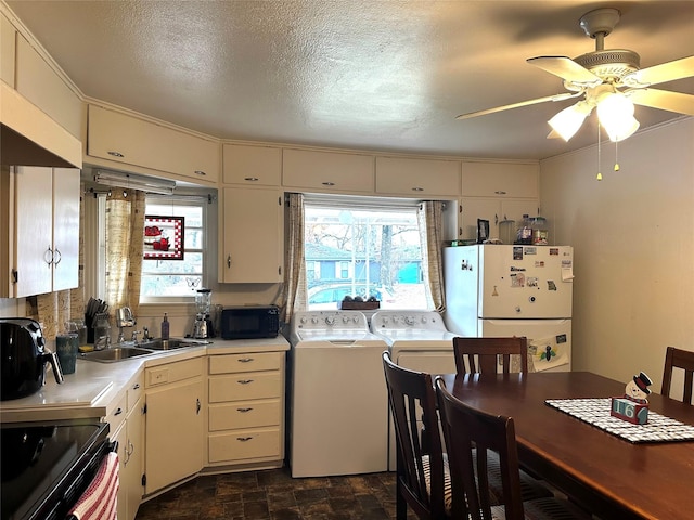 kitchen with black appliances, sink, washer and dryer, ceiling fan, and a textured ceiling