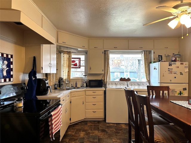 kitchen with black appliances, plenty of natural light, independent washer and dryer, and a textured ceiling