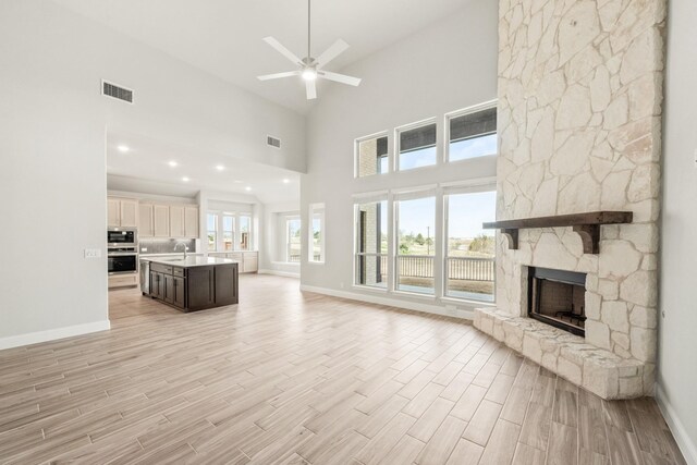 kitchen with stainless steel appliances, premium range hood, a center island with sink, and white cabinetry