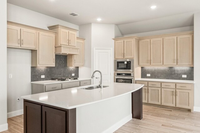 kitchen featuring custom exhaust hood, white cabinetry, a kitchen island with sink, and sink