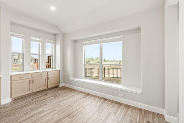 kitchen featuring sink, dishwasher, a fireplace, white cabinets, and a center island with sink