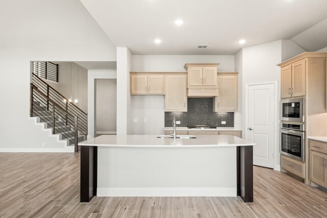 kitchen featuring appliances with stainless steel finishes, sink, a center island with sink, and white cabinets