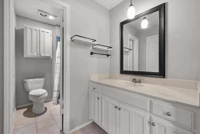 bathroom with tile patterned flooring, vanity, and toilet