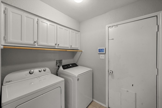 washroom featuring separate washer and dryer, light tile patterned floors, and cabinets