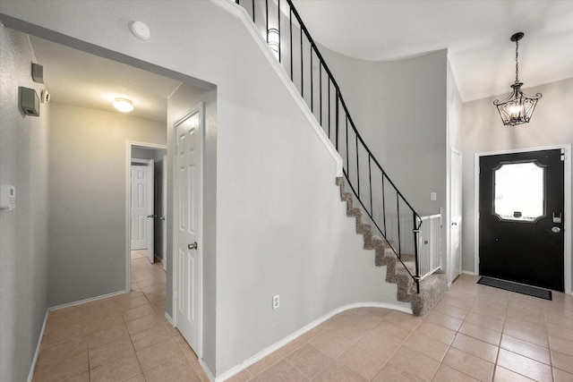 entryway featuring light tile patterned floors and a notable chandelier