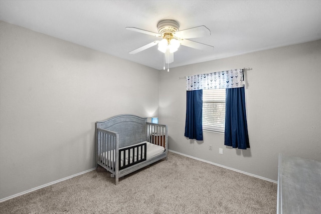 carpeted bedroom with a nursery area and ceiling fan