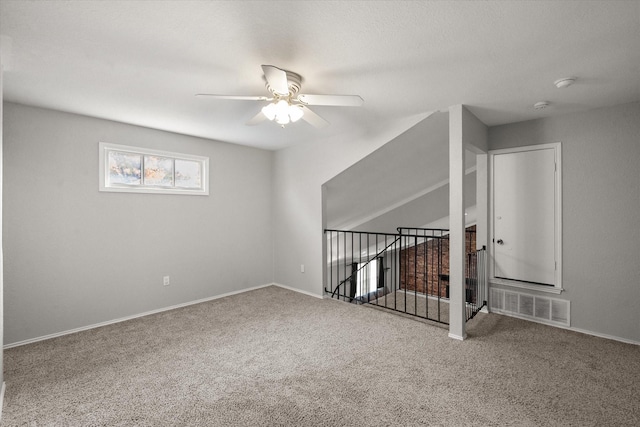 empty room featuring ceiling fan and carpet