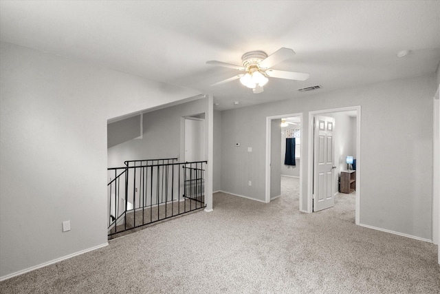 empty room featuring ceiling fan and carpet