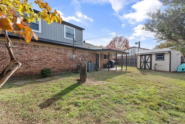 exterior space with central AC unit, a yard, a patio, and a storage unit